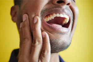 Man holding jaw with a toothache in Saskatoon